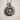 Close-up of vintage style sunflower pendant resting on a textured surface highlighting the oxidized sterling silver finish