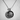 Detailed front view of the vintage style oxidized silver Virgin Mary pendant resting against a textured white wall