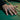 Lifestyle shot showing the handcrafted 101st Airborne ring worn on a man's hand resting on a green pool table.