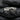 Close-up of the handcrafted handshake ring resting on dark stone, highlighting the oxidized silver band.