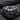 Close-up of gothic winged equality heart ring resting on a dark textured slate background highlighting silver details