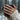 Lifestyle view of the chunky floral engraved cuban chain ring worn on a woman's hand holding a dark ceramic mug