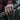 Man's hand holding a wooden axe handle while wearing the oxidized silver twisted rope ring outdoors in the forest.
