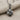 Stemmed Rose Pendant, oxidized, angled view on textured fabric