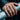 Lifestyle view of person wearing oxidized silver hourglass band ring resting hand on an industrial metal pipe