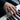 Bold iron sharpens iron signet ring worn on a man's hand while playing a piano, showcasing everyday masculine style.