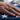 Men's USMC signet ring worn on hand resting over an American flag, showcasing the intricate rope border and engraving