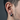 Close-up of modern geometric hoop earring worn on a man's ear highlighting the chunky faceted brushed silver design