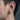 Close-up of geometric bamboo hoop earring worn on male model showing secure hinged closure and smooth finish