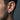 Close-up of a man wearing the brutalist 925 silver weathered hoop earring, showcasing its thick chunky profile.