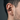Close-up of medieval sword earring worn on male ear cartilage showing the non-piercing spring-tension grip design.