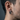 Side view of the oxidized silver twin skull earring worn on a man's ear, showcasing the secure hinged closure