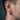 Side view of handcrafted men's gothic cross earring worn on the ear, highlighting the oxidized silver finish
