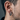 Close-up of oxidized silver sunburst hoop earring worn on a man's ear showcasing the spiked silhouette