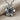 Angled view of elegant plumeria flower pendant in oxidized silver resting elegantly on textured linen fabric background