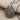 Angled close-up of oxidized silver spiral conch pendant resting on woven fabric displaying deep dimensional ridges and chain