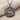 Close-up of the ancient Anatolian stag pendant resting elegantly on a textured beige fabric background.