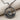 Close-up of the handcrafted sailboat wave pendant showing the intricate oxidized silver ocean waves and dark sail