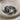 Angled close-up of the hidden face ring on textured fabric highlighting the oxidized silver band and purple gemstones