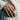 Modern geometric band ring worn on a man's hand resting against a beige linen jacket showing style and scale