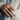 Man wearing handcrafted oxidized sterling silver skull ring on index finger styled with linen blazer