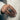 Close-up lifestyle view of handcrafted Optimus Prime ring worn on male hand styled with a beige suit jacket
