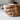 Lovers kissing ring worn on hand holding a white coffee mug highlighting the artistic romantic design in daily wear