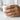 Close-up shot of gold royal crown ring worn on finger while holding a coffee mug showing stylish daily wear