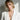 Blonde woman wearing the oxidized silver Persephone ancient Greek coin pendant with an elegant white blazer outfit