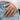 Lifestyle shot of a woman wearing the oxidized silver three eyed raven ring on her hand against a casual denim background