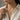 Woman wearing an elegant amethyst solitaire pendant necklace styled with a classic unbuttoned linen shirt