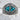 Turquoise dragon eye ring, oxidized silver, front view on stone pedestal