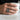 Slightly angled view of the handcrafted fallen angel ring revealing the hyper-realistic anatomical male torso and patina.