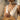 Model wearing two-tone gold ankh pendant medallion necklace with summer linen dress against neutral background