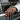 Close-up of a man wearing the oxidized sterling silver cracked cross ring resting his hand on a vintage car door