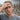 Man wearing handcrafted sterling silver anatomical skull ring on hand placed over forehead lifestyle portrait
