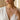 Model wearing a gold Gemini zodiac pendant necklace styled with an elegant white open-neck linen dress