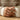 Detailed view of the sculpted rose ring worn on a hand holding a ceramic mug with warm lifestyle lighting