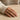 Model wearing a Cuban link chain ring on index finger styled with a cozy knit sweater and natural look
