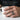 Man wearing oxidized silver Japan waves ring on hand while holding a textured white ceramic coffee mug