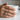 Hand wearing handcrafted oxidized silver Jormungandr sea serpent wave ring holding a white coffee cup