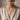 Lifestyle view of model wearing gold Proverbs cross pendant necklace with elegant v-neck dress