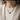 Woman wearing handcrafted sterling silver skull pearl choker styled elegantly over a light cream sweater