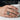 Sacred Heart ring worn on a man's hand while holding a white ceramic mug, showing daily wear comfort and fit