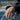 Hand wearing oxidized silver Pisces skull signet ring while resting arm on car window frame outdoors