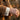 Close-up of men's wrist wearing oxidized silver lion crown cufflink with French cuff shirt and tan coat