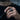 Handcrafted oxidized silver ancient deity face ring worn on male hand holding sunglasses outdoors