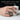 Handcrafted oxidized silver pisces memento mori signet ring worn on hand holding white ribbed mug