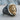 Scroll Jesus Christ Ring, two-tone finish, three-quarter view on wood