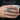 Floral cross signet ring in oxidized silver, worn on model hand